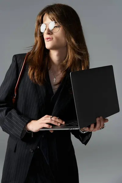 Um jovem elegante confiantemente se envolve com seu laptop, irradiando charme moderno. — Fotografia de Stock