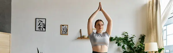 A dedicated athlete engages in yoga at home, showcasing strength and focus in stylish active wear. — Stock Photo