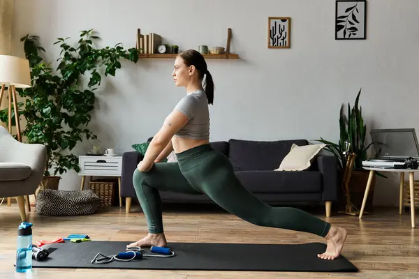 Eine sportliche junge Frau trainiert in aktiver Kleidung und konzentriert sich mit Leidenschaft und Energie auf das Heimtraining. — Stockfoto