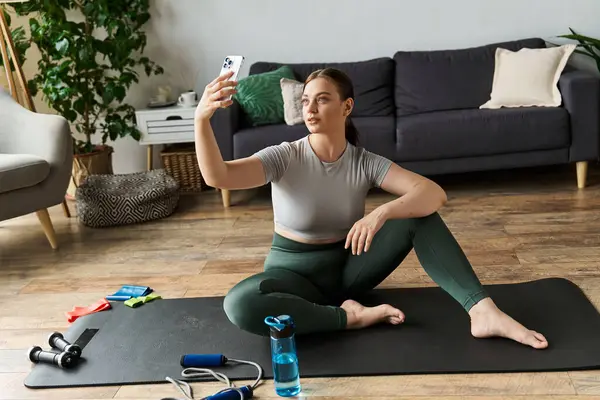 A sportive young woman in a crop top and leggings exercises at home, capturing her workout moment. — Stock Photo