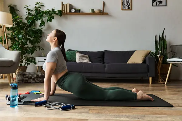 A sportive woman engages in a home workout, stretching and enhancing her flexibility in active wear. — Stock Photo