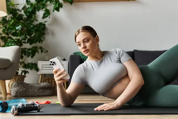 A dedicated young woman in active wear engages in a home workout, focusing on her fitness routine. — Stock Photo