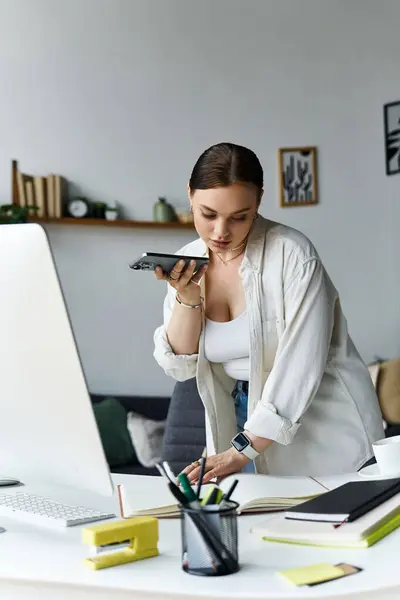 Envolvida em trabalho produtivo, uma jovem equilibra tarefas enquanto fala no telefone em casa. — Fotografia de Stock