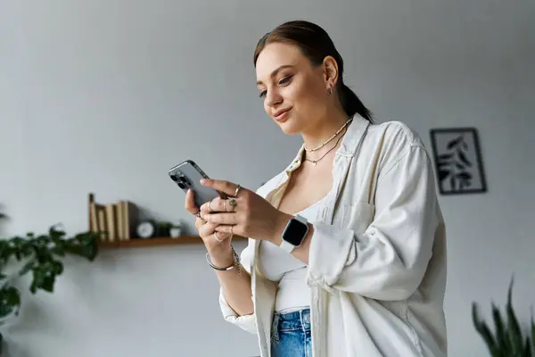 The young woman engages with her smartphone, balancing work and leisure in a cozy home setting. — Stock Photo
