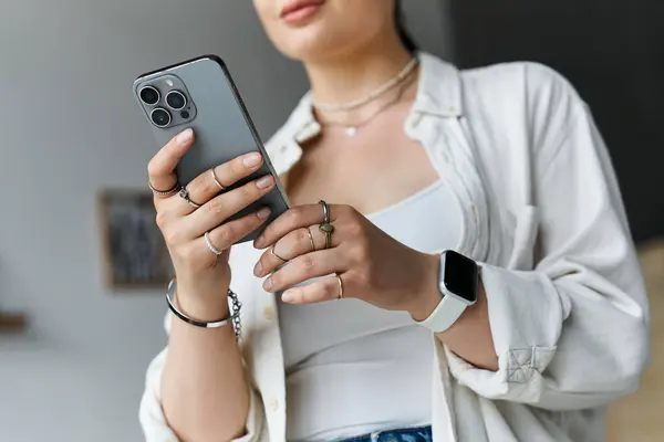 A young woman dressed casually is focused on her work at home, using smartphone — Stock Photo