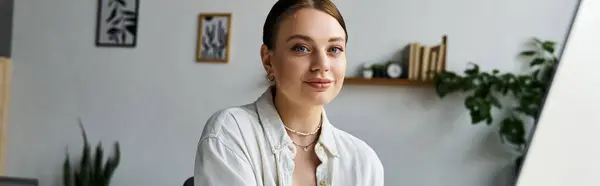 A young woman in stylish casual clothing focuses on her tasks while working from home in a bright setting. — Stock Photo