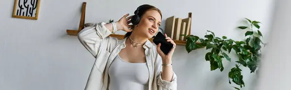 Una giovane donna in abbigliamento casual canta insieme alla musica — Foto stock