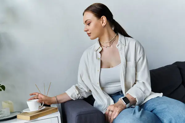A young woman focuses on her work at home, sipping coffee while surrounded by a cozy atmosphere. — Stock Photo