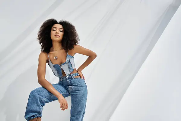 A confident young woman showcases her fashion sense in trendy denim, striking a pose. — Stock Photo