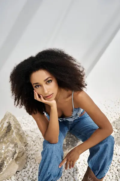A beautiful young African American woman exudes confidence in stylish attire, seated gracefully. — Stock Photo