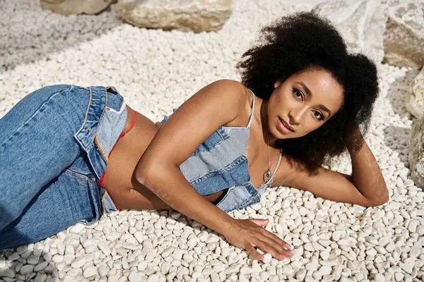 An elegant young woman relaxes gracefully, showcasing her fashionable denim ensemble. — Stock Photo