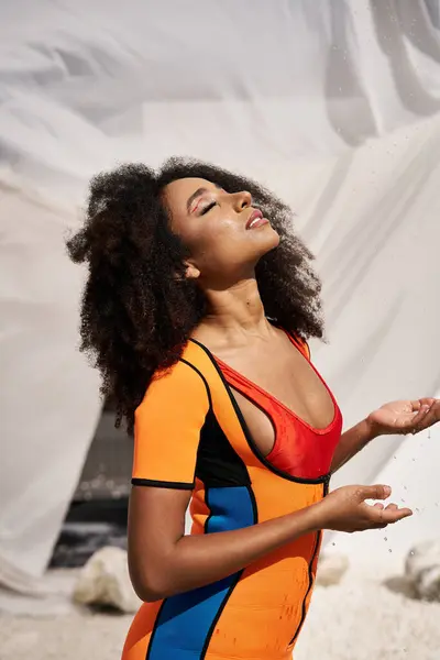 A young African American woman radiates beauty in a colorful outfit, embracing the sunlight. — Stock Photo