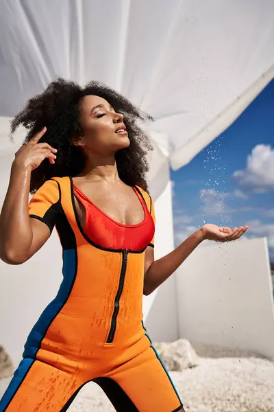 A confident young woman showcases her stylish outfit while basking in sunlight. — Stock Photo