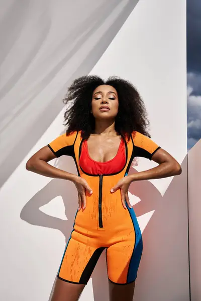 A stylish young woman exudes confidence in a colorful outfit, basking in warm sunlight. — Stock Photo