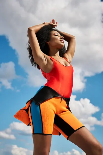 A stylish young woman poses gracefully in colorful summer attire, embodying confidence and joy. — Stock Photo