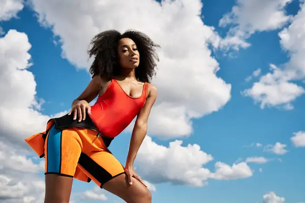 A beautiful young African American woman showcases trendy attire under a bright sky. — Stock Photo
