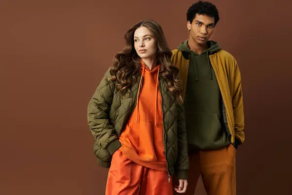 A fashionable couple showcases their stunning autumn outfits, radiating warmth and style. — Stock Photo