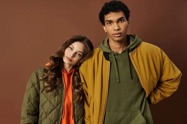A fashionable young couple showcases their vibrant autumn outfits while sharing a moment together. — Stock Photo