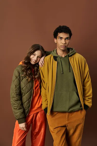 A fashionable couple showcases their trendy autumn styles with cheerful expressions. — Stock Photo