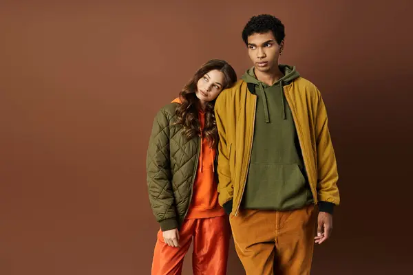 A fashionable young couple models colorful autumn clothing, showcasing trendy styles and cozy vibes. — Stock Photo