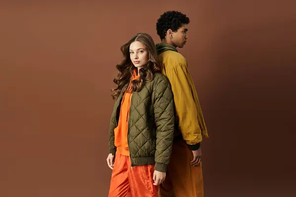 A stylish couple embraces autumn fashion with bold colors and confident poses, radiating warmth. — Stock Photo