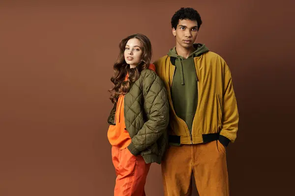 A young couple showcases their trendy autumn attire with vibrant colors, embodying seasonal fashion. — Stock Photo