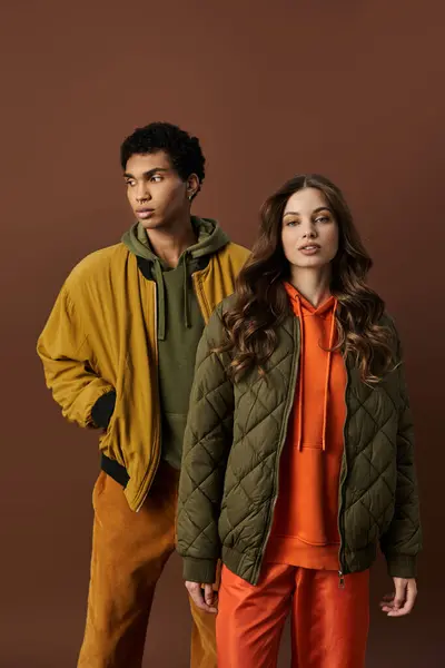 A fashionable couple dons vibrant autumn attire, embodying warmth and style amidst rich colors. — Stock Photo