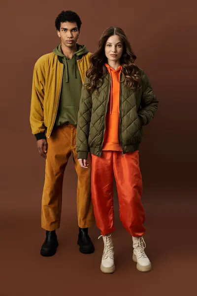 A stylish couple embraces autumn fashion with bold colors and layered outfits, exuding warmth. — Stock Photo