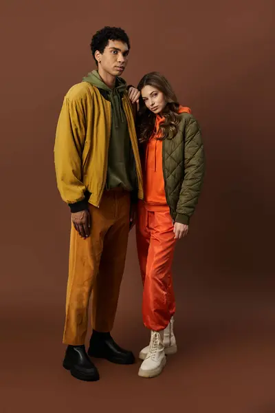 A stylish couple showcases trendy autumn outfits in rich, vibrant colors, exuding warmth. — Stock Photo
