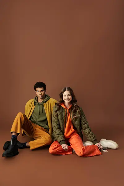 A stylish pair relaxes in cozy autumn attire, embodying seasonal fashion trends. — Stock Photo