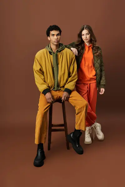 A fashionable couple dressed in autumn attire poses confidently, exuding style and warmth. — Stock Photo