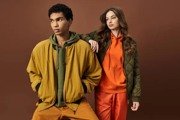 A fashionable young couple poses together, showcasing vibrant autumn attire with confidence. — Stock Photo