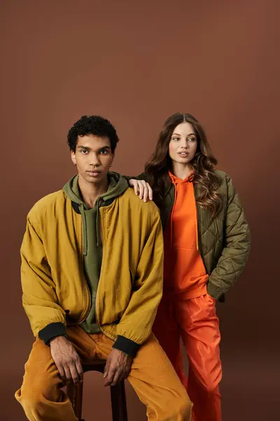 The stylish couple showcases vibrant autumn attire, blending colors perfectly for the season. — Stock Photo