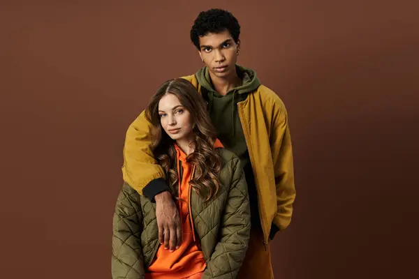 A fashionable couple showcases their stylish autumn attire against a rich, earthy background. — Stock Photo