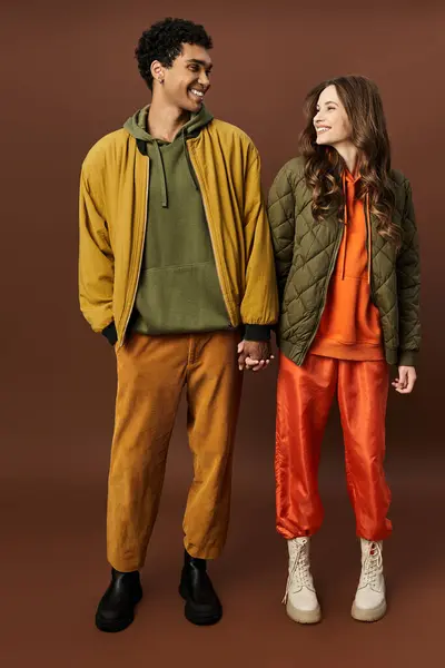 A fashionable couple enjoys the autumn atmosphere while holding hands in trendy attire. — Stock Photo