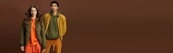 A stylish couple dressed in bold autumn outfits radiates warmth and modern elegance in fall. — Stock Photo