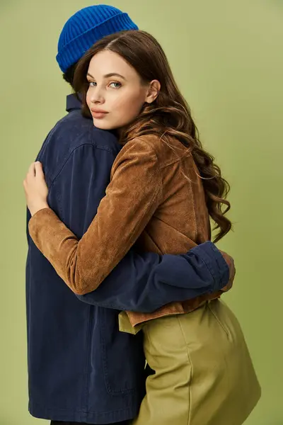 A fashionable couple shares a warm embrace, showcasing vibrant autumn styles. — Stock Photo