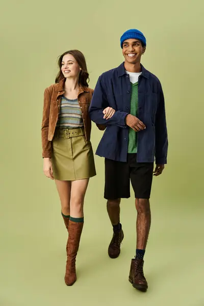 A stylish couple embraces autumn with colorful outfits while enjoying a cheerful walk together. — Stock Photo