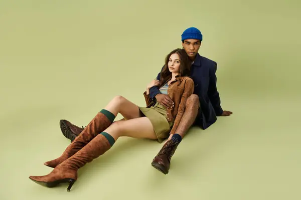 A fashionable couple relaxes together, embracing the spirit of autumn in colorful attire. — Stock Photo
