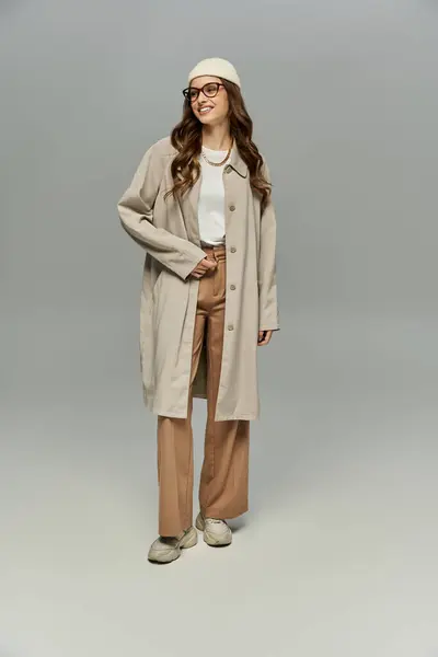 Appealing woman in elegant autumn attire posing on gray backdrop. — Stock Photo