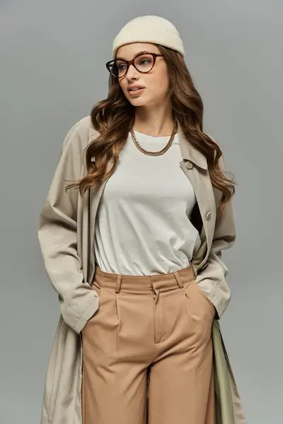 Young woman in elegant autumn attire posing on gray backdrop. — Stock Photo