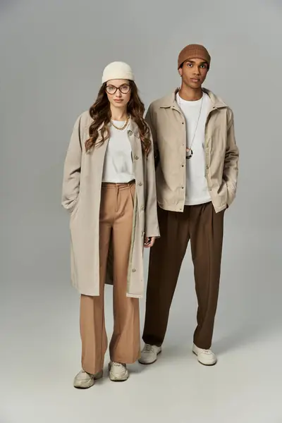 The couple sports stylish autumn outfits, adorned with warm accessories, in a snug environment. — Stock Photo