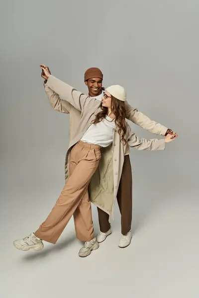 A fashionable couple joyfully poses in vibrant autumn outfits, embodying warmth and style. — Stock Photo