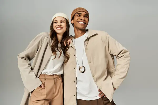 A fashionable couple showcases their autumn styles with smiles, exuding warmth and joy together. — Stock Photo