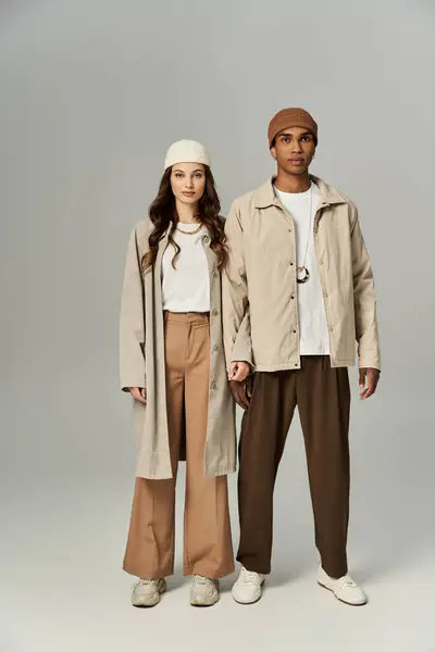 A fashionable couple showcases their vibrant autumn attire while standing side by side. — Stock Photo
