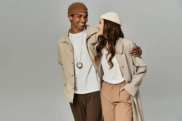 A young couple joyfully shares a moment in colorful autumn attire, exuding warmth. — Stock Photo