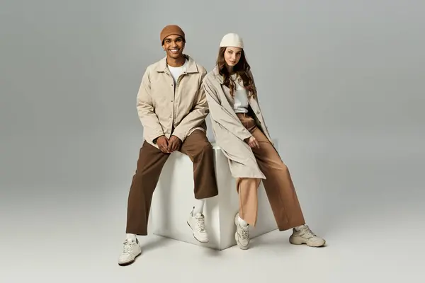A chic couple enjoys vibrant autumn styles while seated, basking in the cozy urban ambiance. — Stock Photo