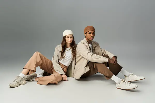 A young couple sits in trendy autumn outfits, radiating style and warmth in vibrant hues. — Stock Photo
