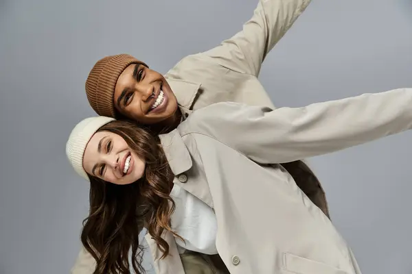 Vestita in elegante abbigliamento autunnale, una giovane coppia irradia felicità mentre posa giocosamente insieme. — Foto stock