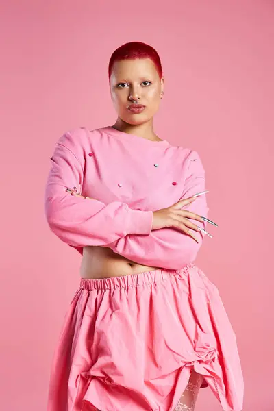 A jovem mostra com confiança seu cabelo rosa único e traje elegante contra um pano de fundo brincalhão. — Fotografia de Stock